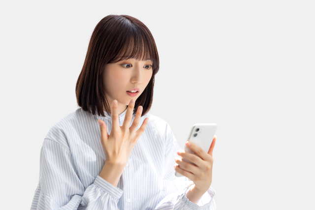 スマホを見て驚く女性